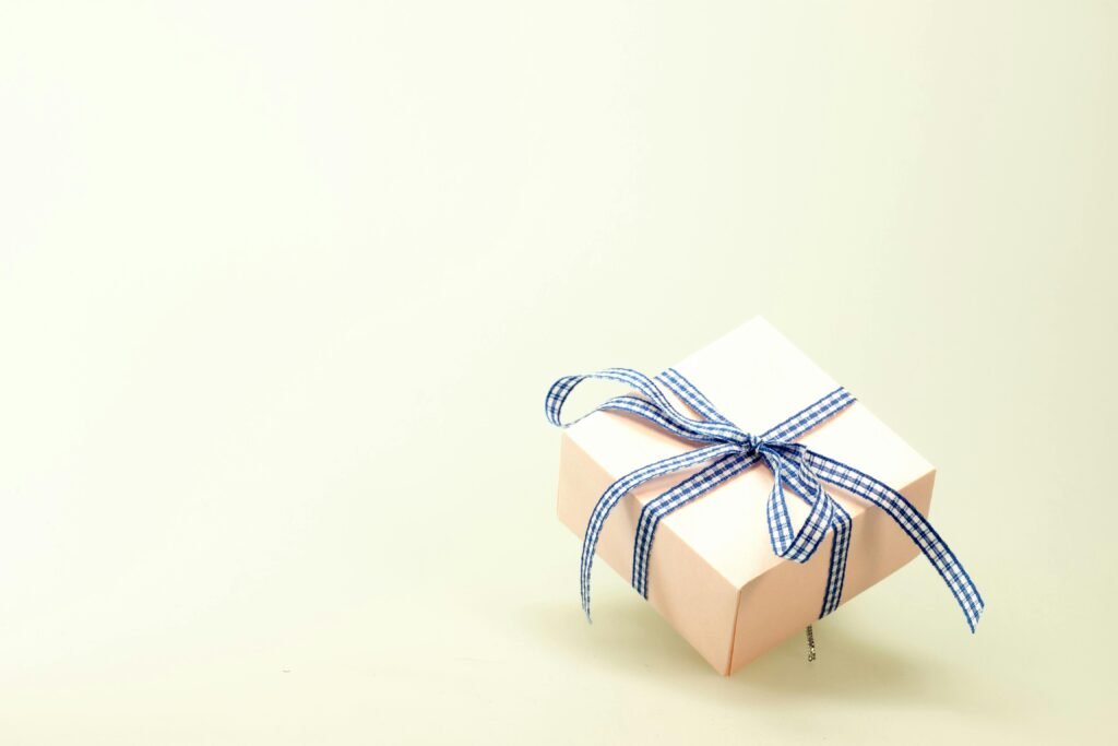 Pink gift box with blue ribbon on a soft background, perfect for celebrations and branding.